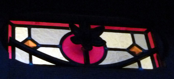 Détail de la porte précédente : une fleur sort du disque supérieur