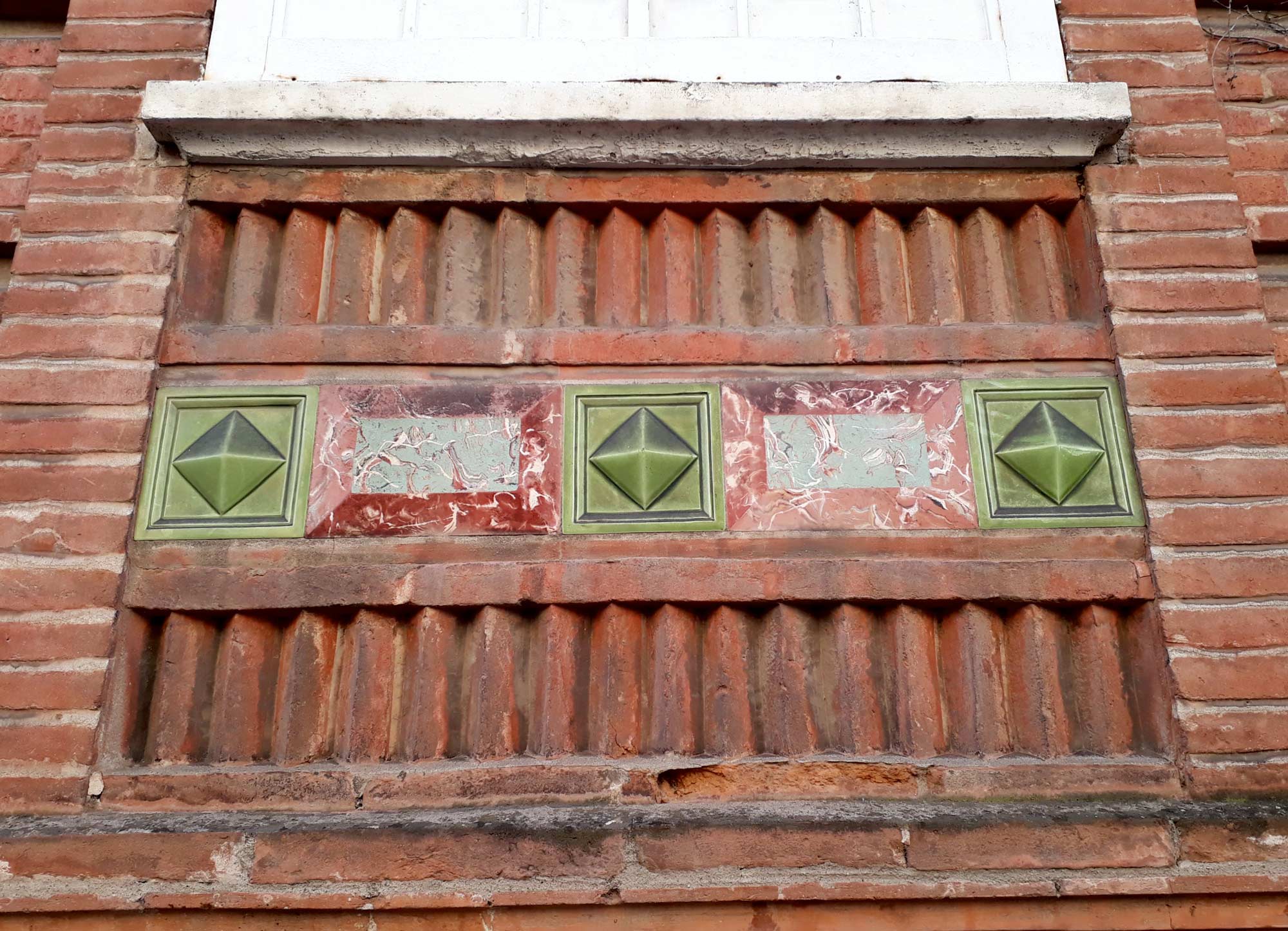 Rue Falguière. Séduisant appareil pour cette allège de fenêtre (cabochons, plaque de faux marbre, briquettes). 